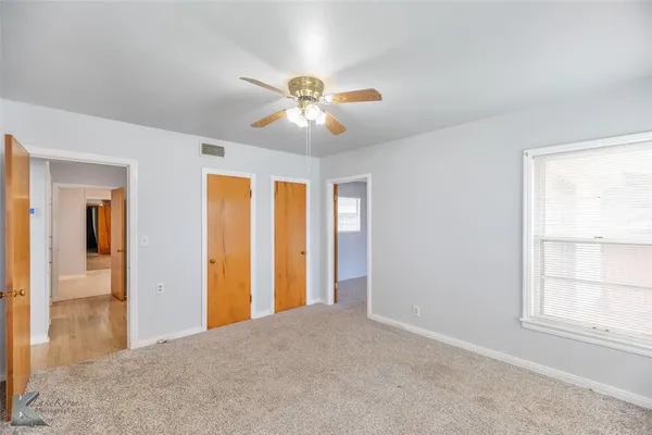 a view of a house with a yard and a large tree