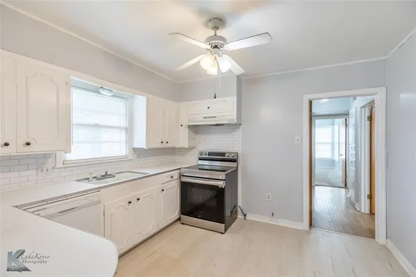 a kitchen with cabinets stainless steel appliances and a window