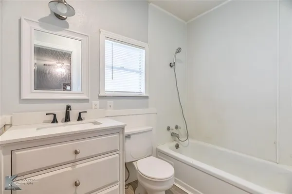 a bathroom with a granite countertop toilet a sink and a bathtub