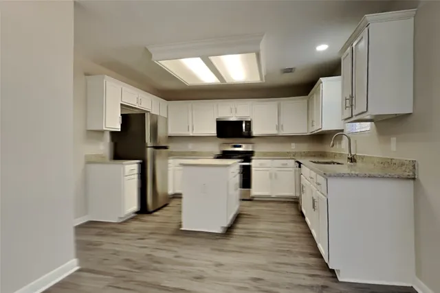 a kitchen with granite countertop white cabinets and white appliances