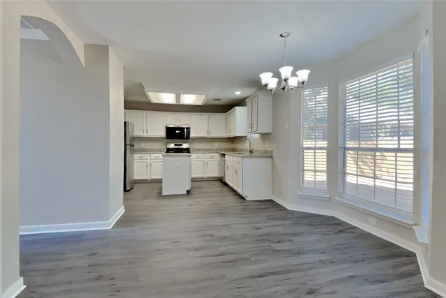 a view of a kitchen with granite countertop stainless steel appliances and wooden floor
