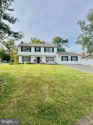 a view of a house with a big yard and large trees