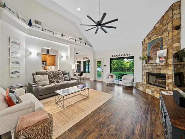 a living room with furniture a fireplace and a large window