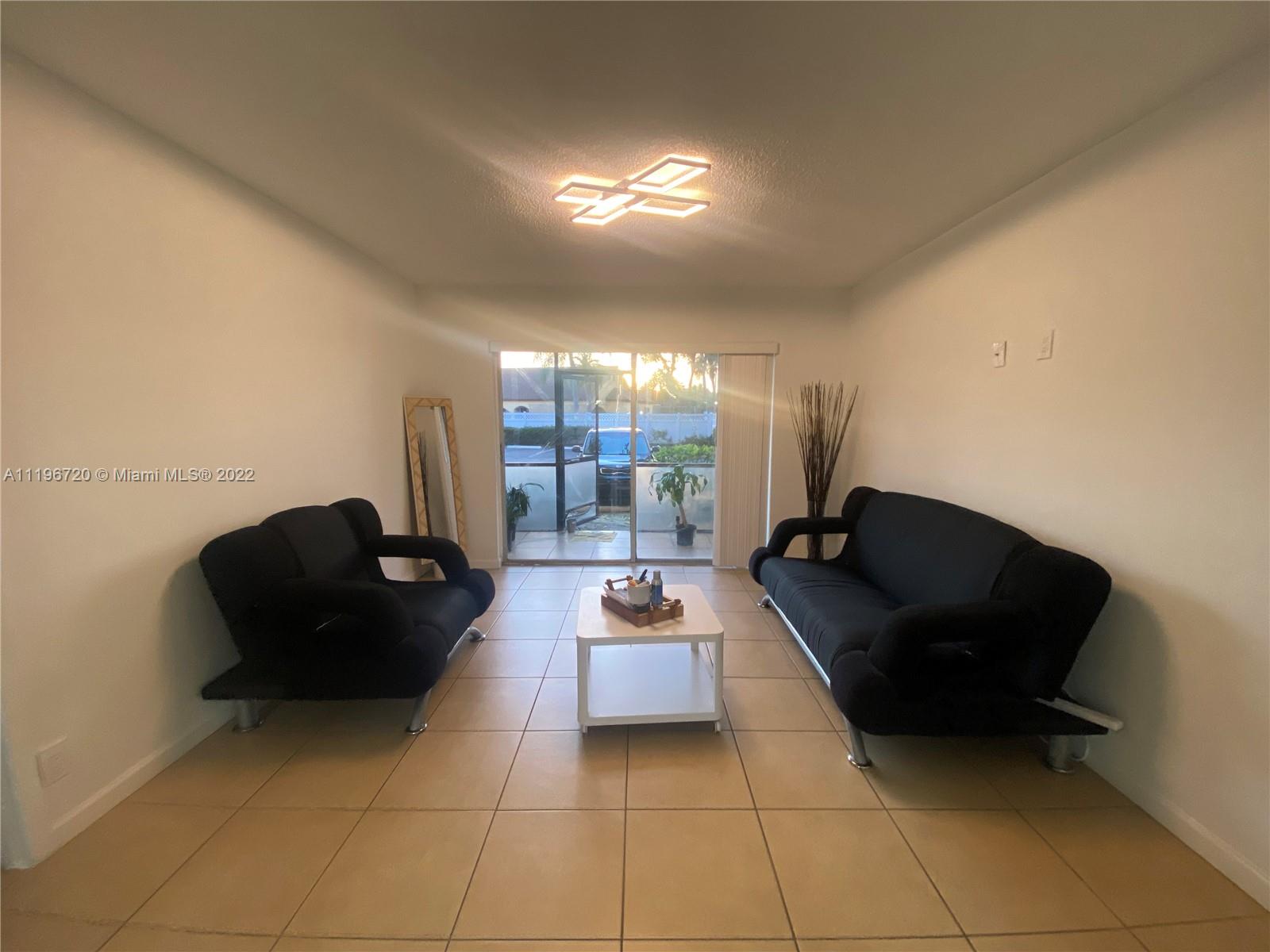 480 Northwest 20th Street, Unit 1030 Boca Raton, FL 33431 - Photo 10 of 16 a living room with furniture and a lamp