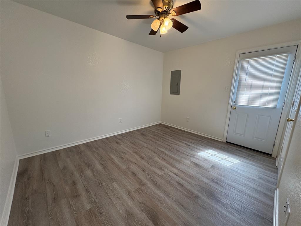 404 South Anglin Street, Unit B Cleburne, TX 76031 - Photo 11 of 12 a view of an empty room with wooden floor and a window
