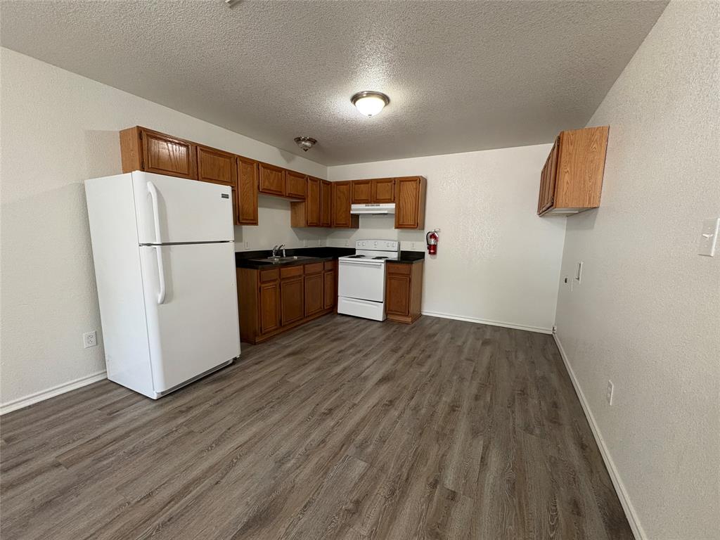 404 South Anglin Street, Unit B Cleburne, TX 76031 - Photo 12 of 12 a kitchen with a refrigerator a stove top oven a sink and dishwasher