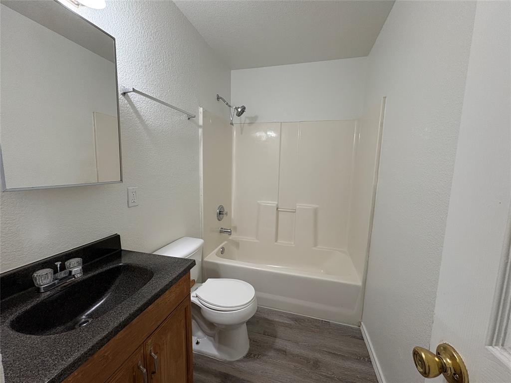 404 South Anglin Street, Unit B Cleburne, TX 76031 - Photo 6 of 12 a bathroom with a sink a toilet and shower