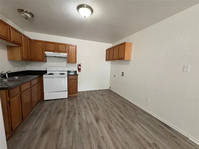 a kitchen with a wooden floor and a stove top oven