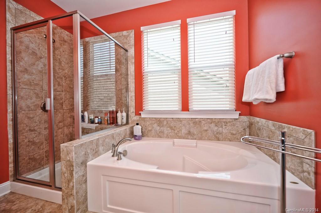 4002 Fallondale Road Waxhaw, NC 28173 - Photo 18 of 24 a white bath tub sitting next to a white sink and a vanity