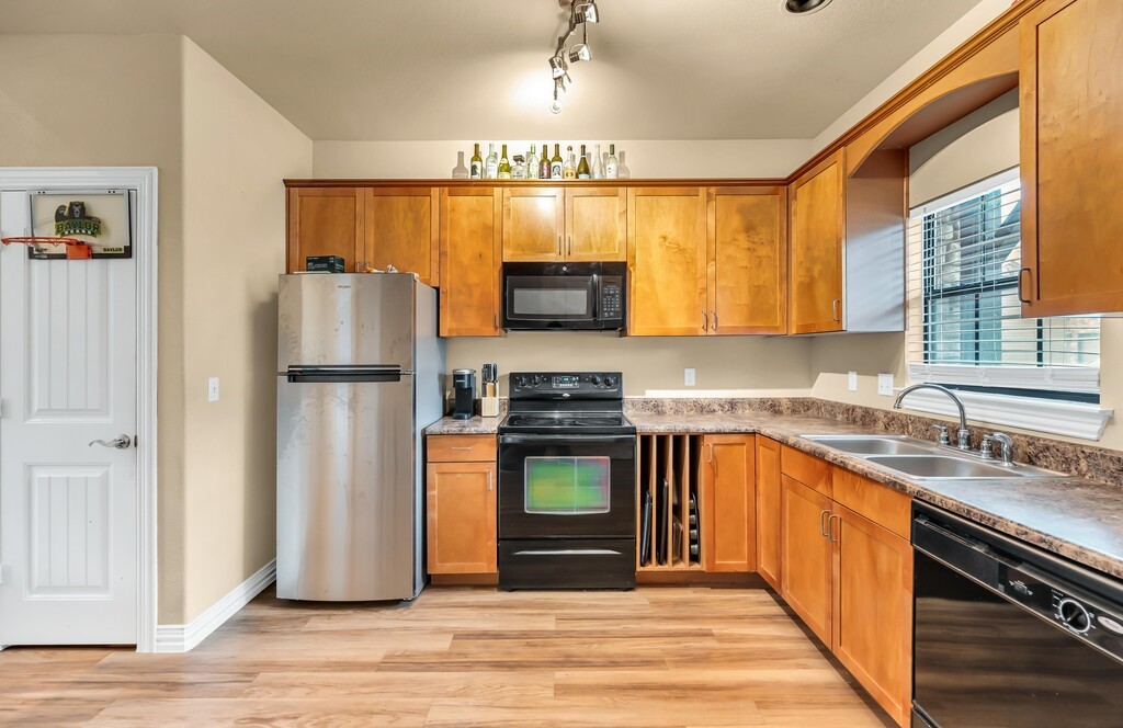 2410 2nd Street South, Unit 1056 Waco, TX 76706 - Photo 11 of 37 a kitchen with a refrigerator and a sink