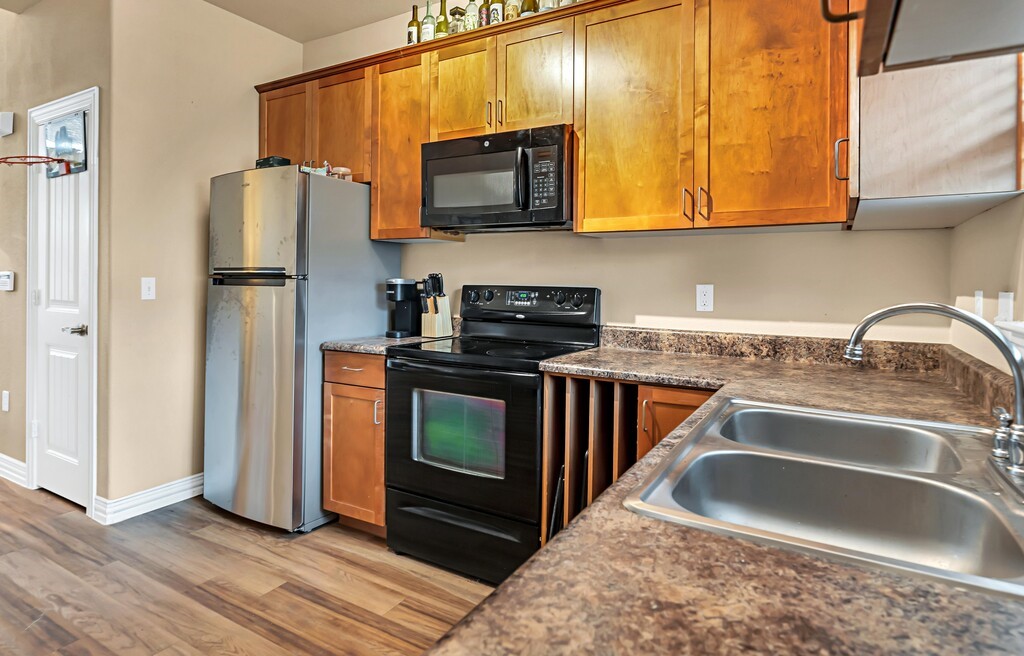 2410 2nd Street South, Unit 1056 Waco, TX 76706 - Photo 12 of 37 a kitchen with stainless steel appliances granite countertop a refrigerator stove and sink
