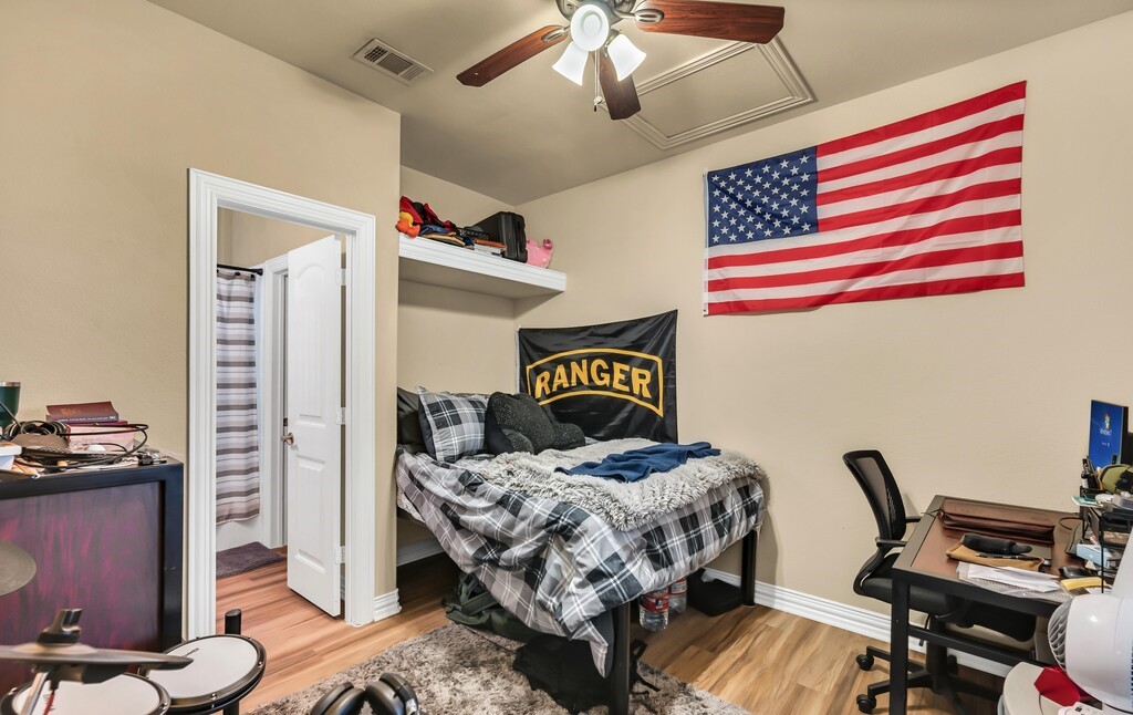 2410 2nd Street South, Unit 1056 Waco, TX 76706 - Photo 20 of 37 a bedroom with a bed and a chandelier