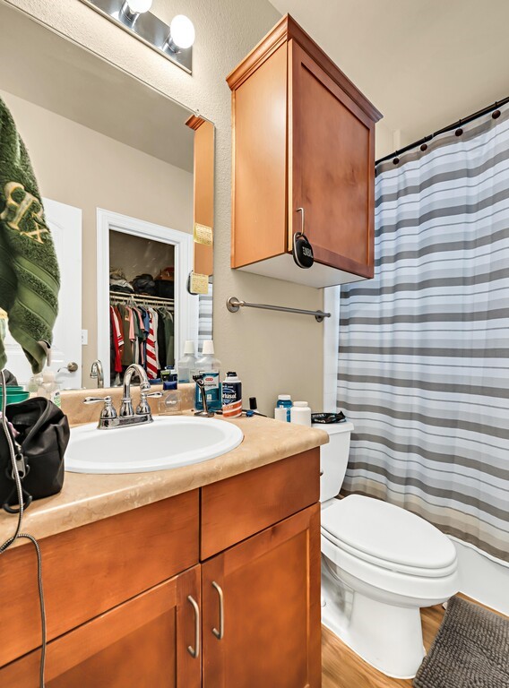 2410 2nd Street South, Unit 1056 Waco, TX 76706 - Photo 22 of 37 a bathroom with a sink a toilet and mirror