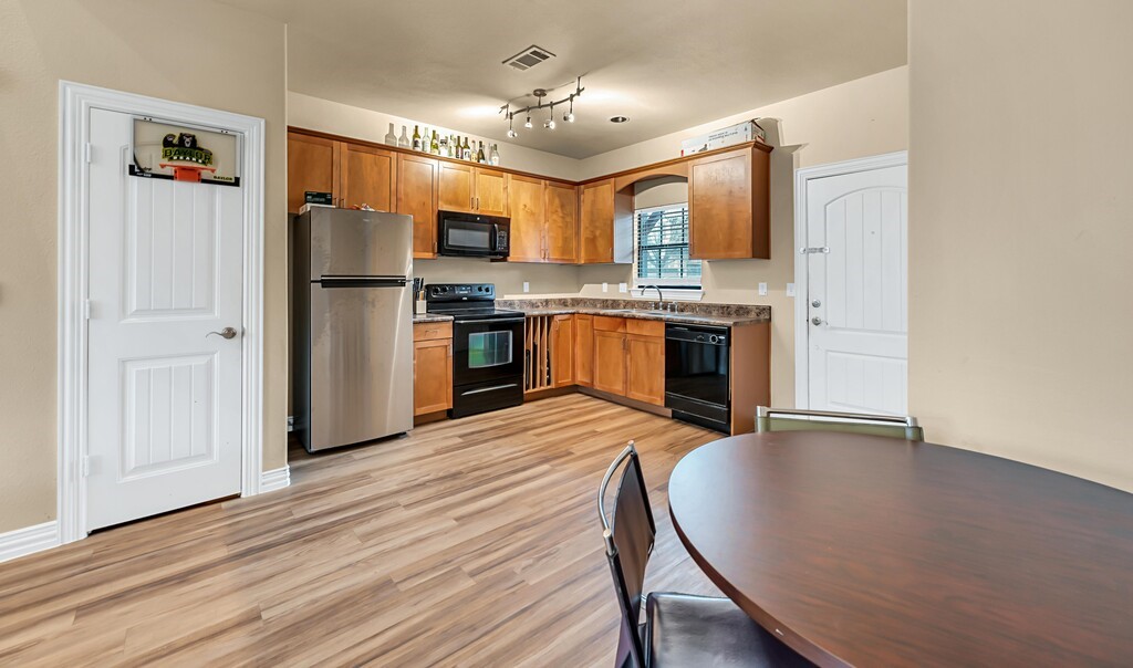 2410 2nd Street South, Unit 1056 Waco, TX 76706 - Photo 9 of 37 a kitchen with stainless steel appliances granite countertop a stove refrigerator and a sink