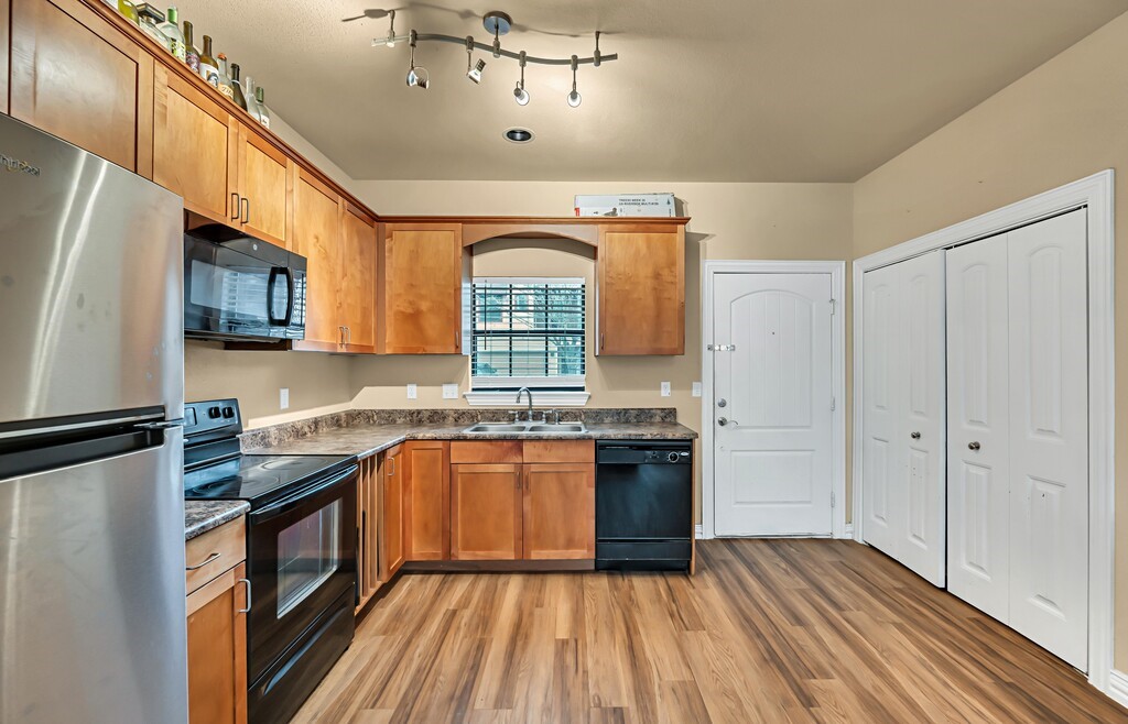2410 2nd Street South, Unit 1056 Waco, TX 76706 - Photo 10 of 37 a kitchen with stainless steel appliances granite countertop a stove a sink dishwasher and a refrigerator