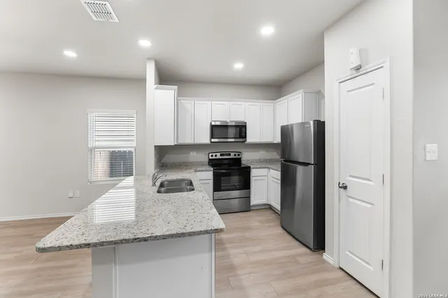 a kitchen with refrigerator and microwave