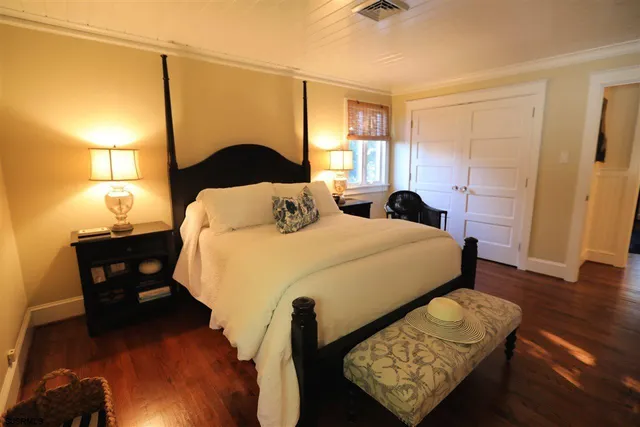 a bedroom with a bed and wooden floor