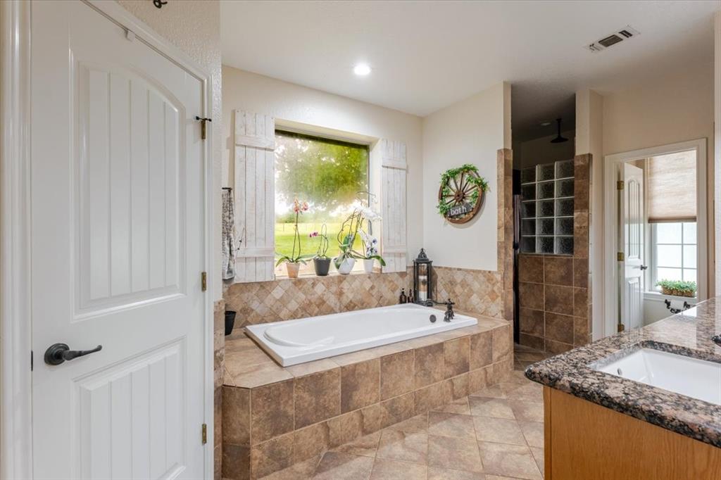 318 East Lone Star Road Poolville, TX 76487 - Photo 10 of 33 a spacious bathroom with a granite countertop tub sink and mirror