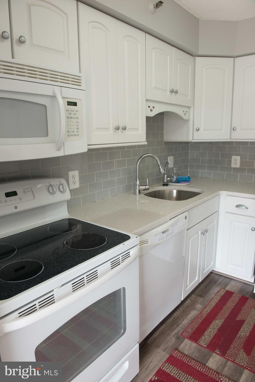 1301 North Courthouse Road, Unit 1507 Arlington, VA 22201 - Photo 11 of 35 a kitchen with granite countertop white cabinets and white appliances