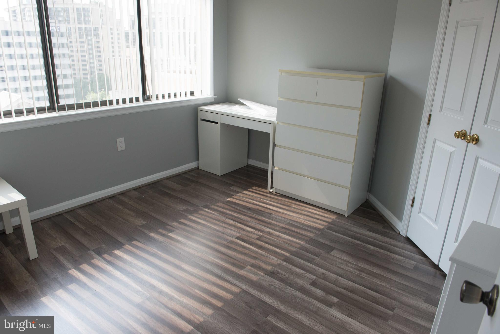 1301 North Courthouse Road, Unit 1507 Arlington, VA 22201 - Photo 17 of 35 a view of an empty room with a window and wooden floor