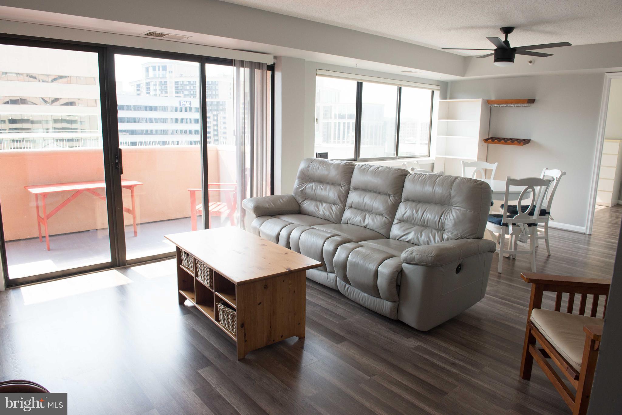 1301 North Courthouse Road, Unit 1507 Arlington, VA 22201 - Photo 2 of 35 a living room with furniture and a large window