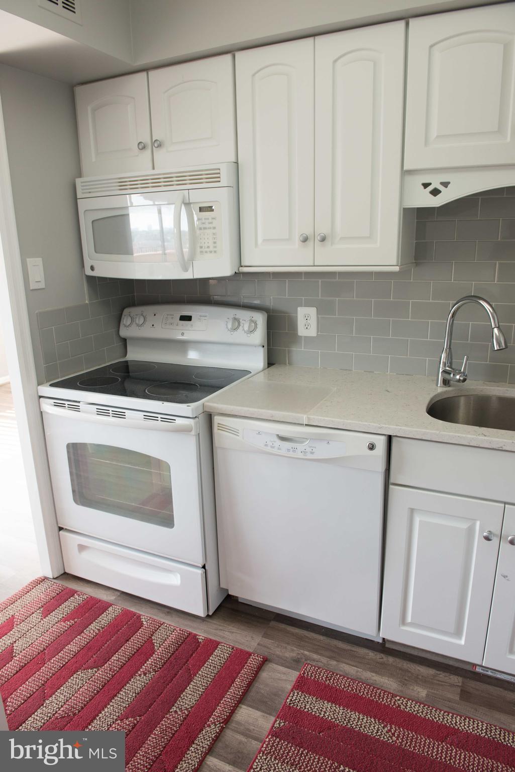 1301 North Courthouse Road, Unit 1507 Arlington, VA 22201 - Photo 8 of 35 a kitchen with white cabinets and white appliances