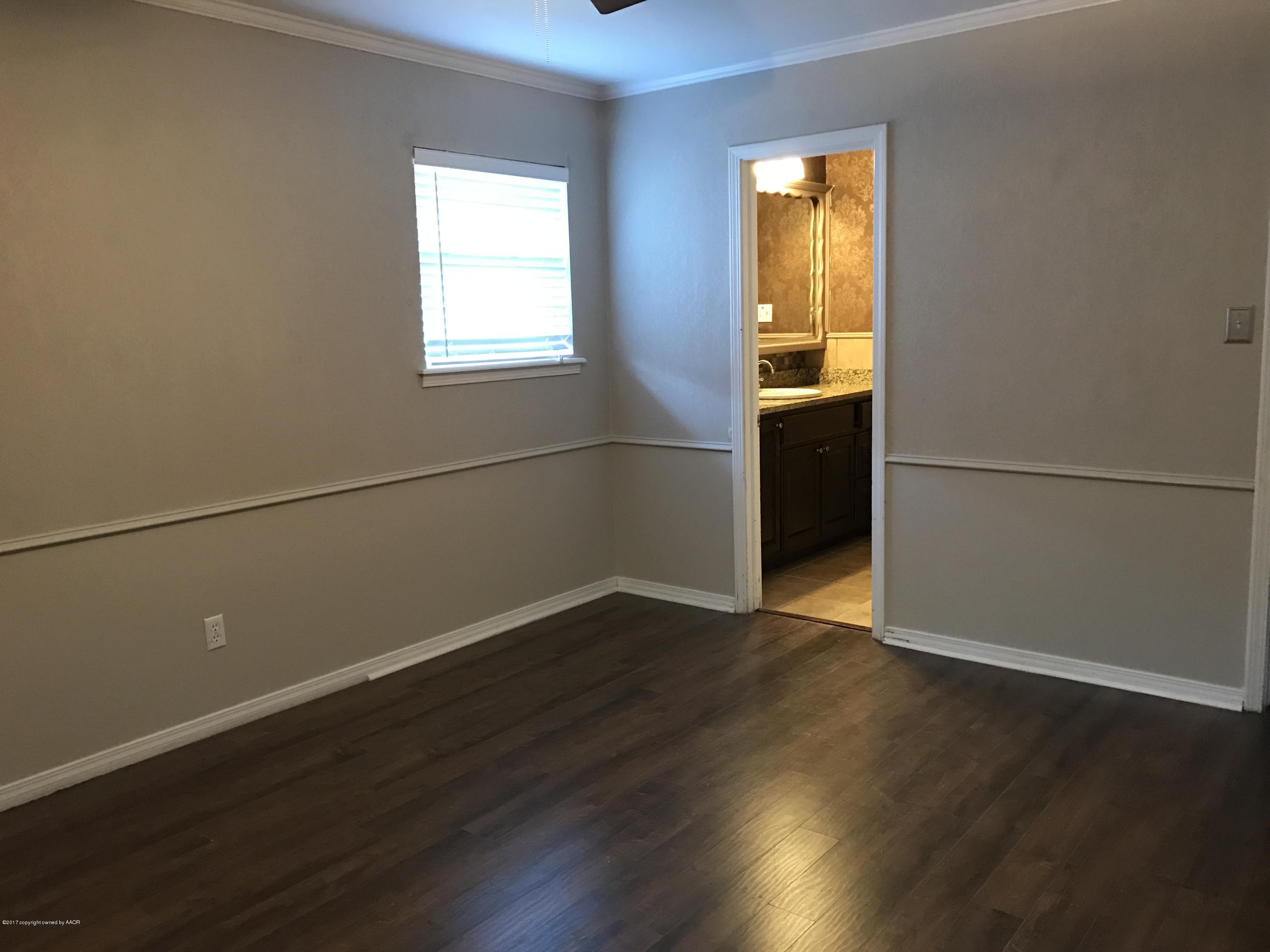 3313 Lombard Road Amarillo, TX 79106 - Photo 11 of 20 an empty room with wooden floor and windows