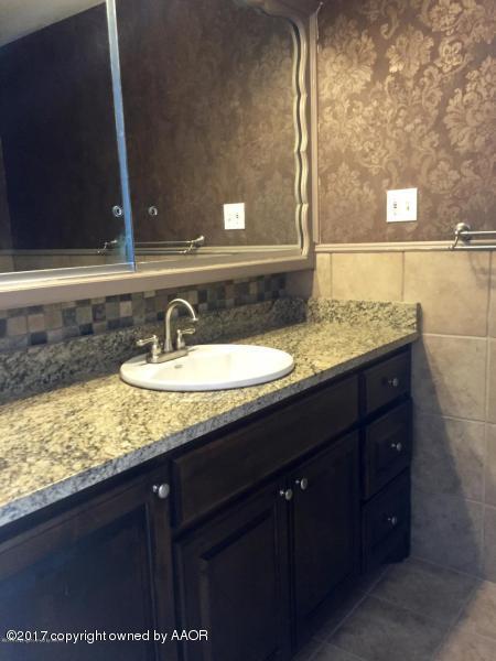 3313 Lombard Road Amarillo, TX 79106 - Photo 12 of 20 a bathroom with a sink and a mirror