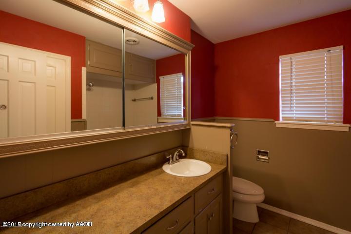 3313 Lombard Road Amarillo, TX 79106 - Photo 14 of 20 a bathroom with a granite countertop sink toilet and mirror