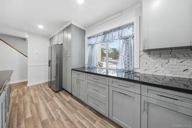 a view of kitchen with granite countertop cabinets and window