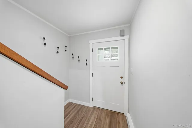 a view of hallway with closet and wooden floor