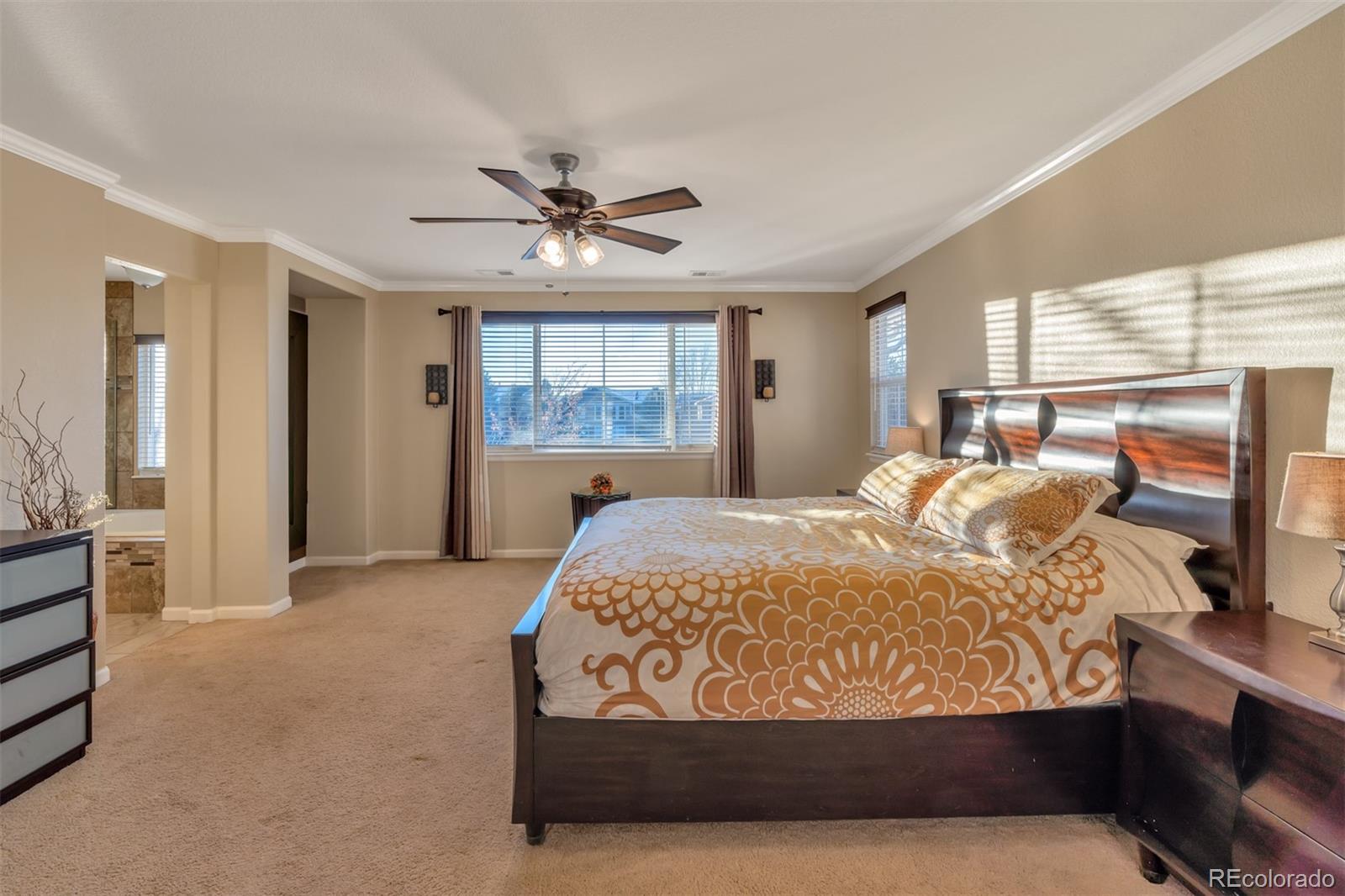 10735 Wynspire Road Highlands Ranch, CO 80130 - Photo 23 of 40 a bedroom with a large bed and a chandelier