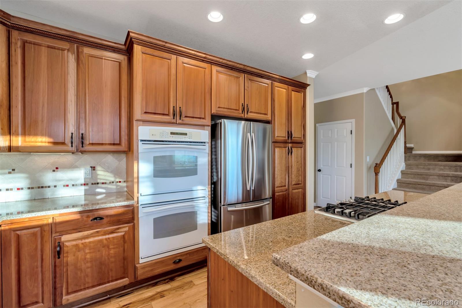 10735 Wynspire Road Highlands Ranch, CO 80130 - Photo 9 of 40 a kitchen with stainless steel appliances granite countertop a refrigerator and a sink