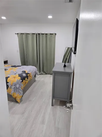 a bedroom with a bed and a large mirror