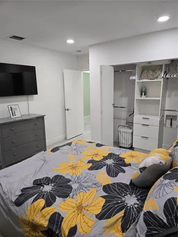 a bedroom with a bed and a flat screen tv