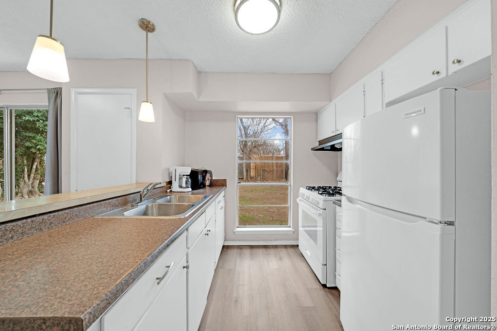 6706 Red Bluff Road San Antonio, TX 78218 - Photo 9 of 17 a kitchen with white cabinets and stainless steel appliances