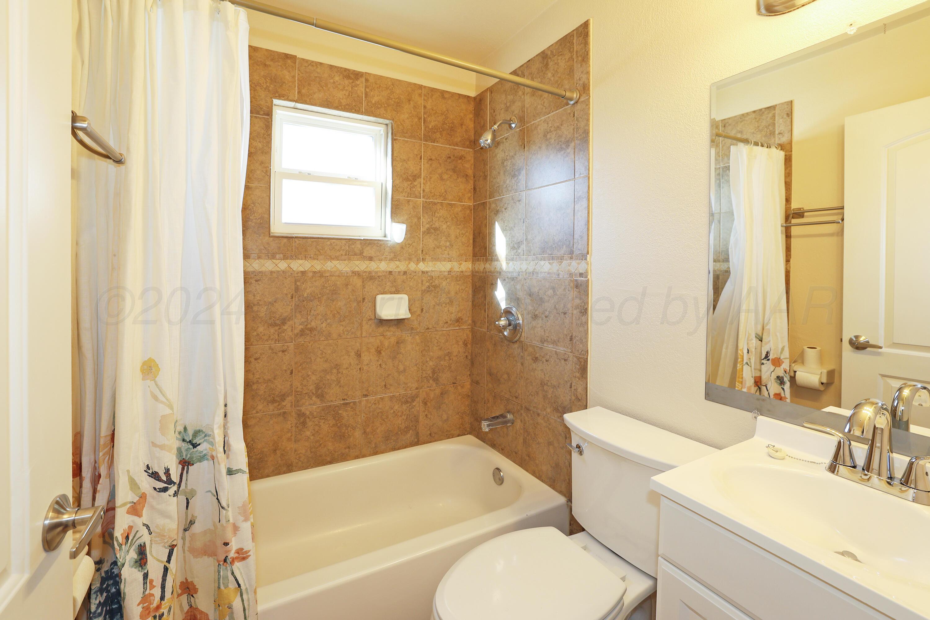 4612 South Parker Street Amarillo, TX 79110 - Photo 15 of 24 a bathroom with a sink toilet and shower
