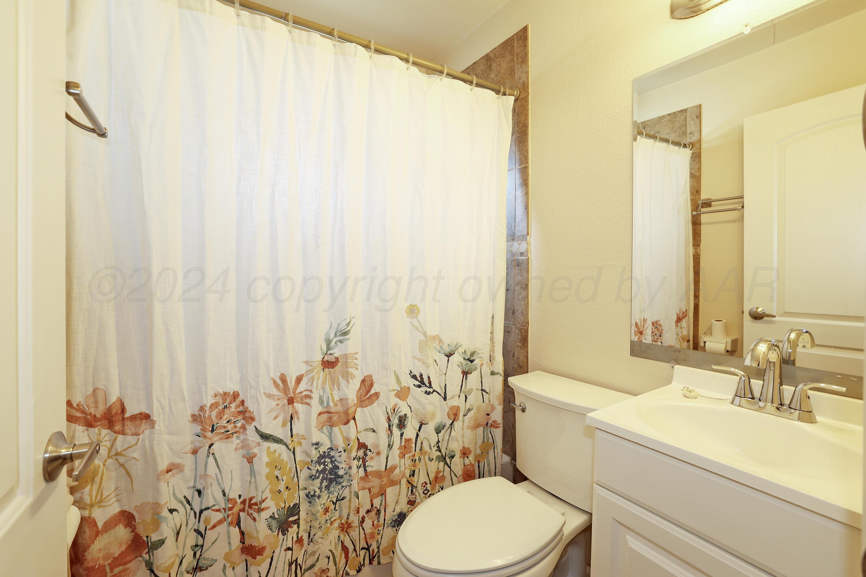 4612 South Parker Street Amarillo, TX 79110 - Photo 16 of 24 a bathroom with a sink a toilet and a mirror