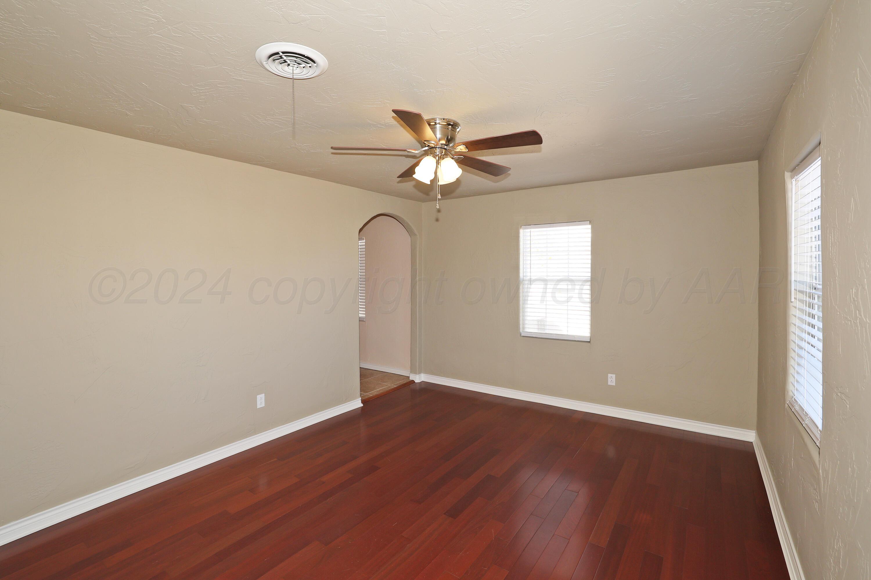 4612 South Parker Street Amarillo, TX 79110 - Photo 4 of 24 wooden floor in an empty room with a window
