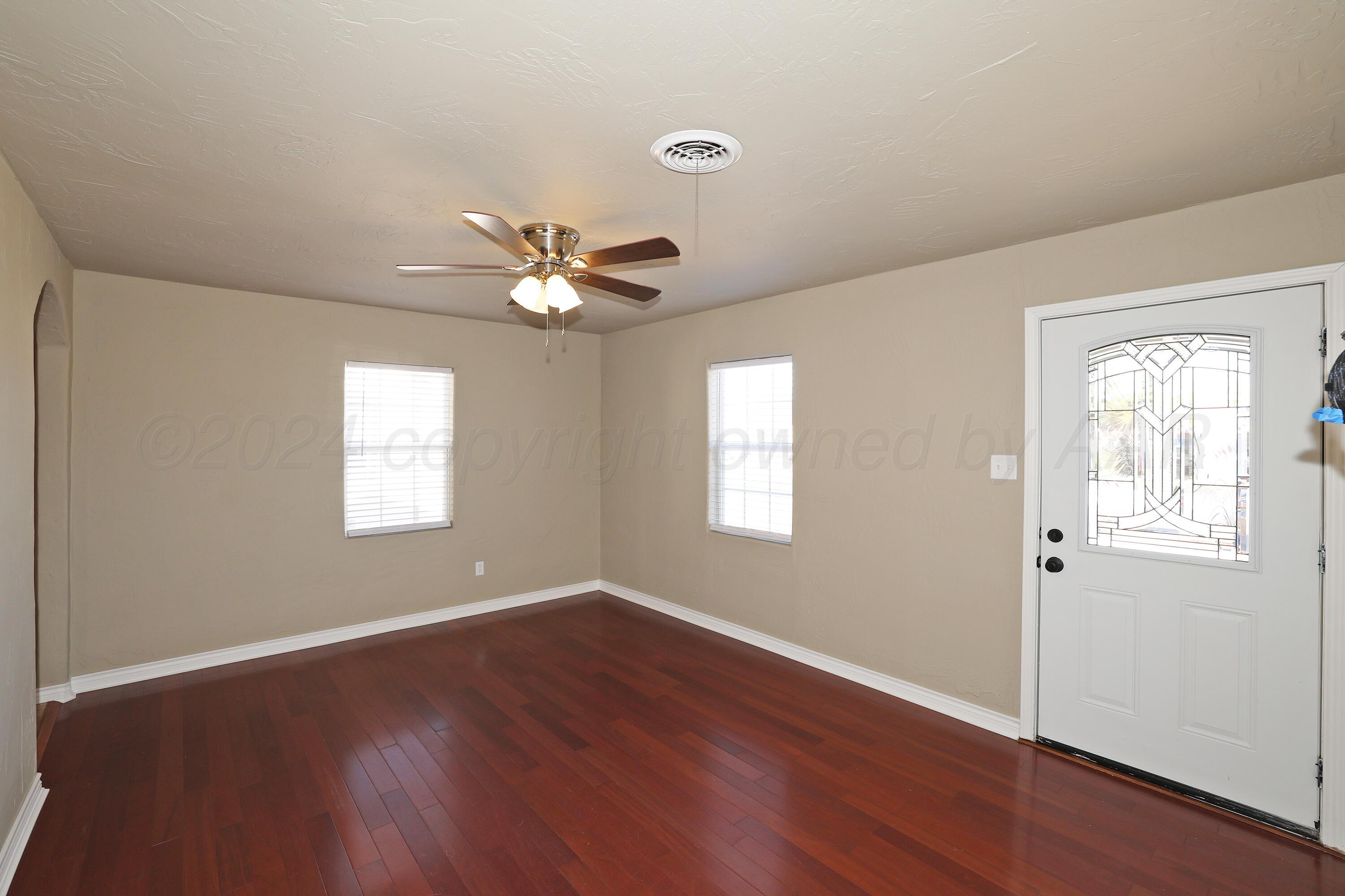 4612 South Parker Street Amarillo, TX 79110 - Photo 5 of 24 a view of an empty room with wooden floor and a window