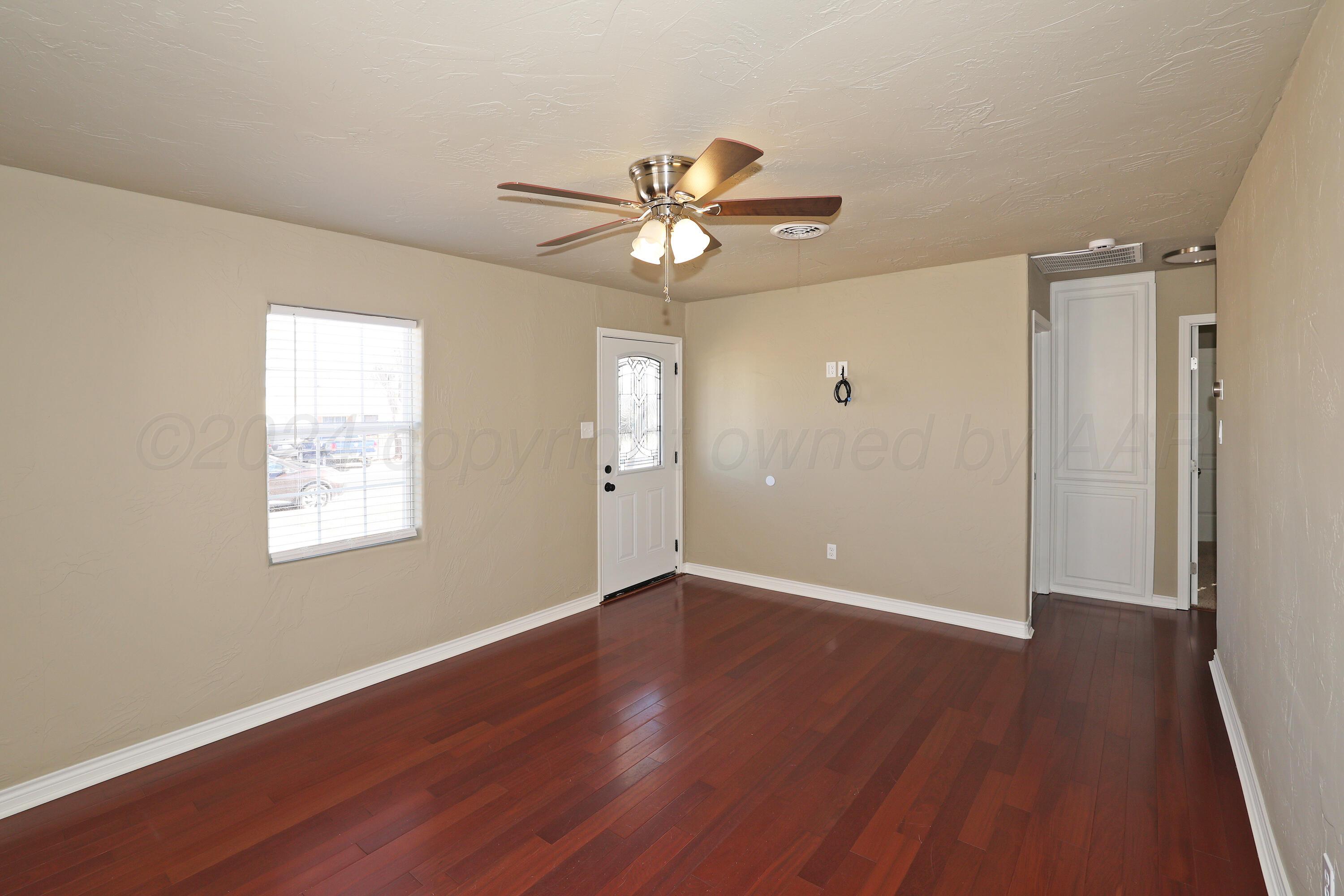 4612 South Parker Street Amarillo, TX 79110 - Photo 6 of 24 a view of an empty room with wooden floor and a window