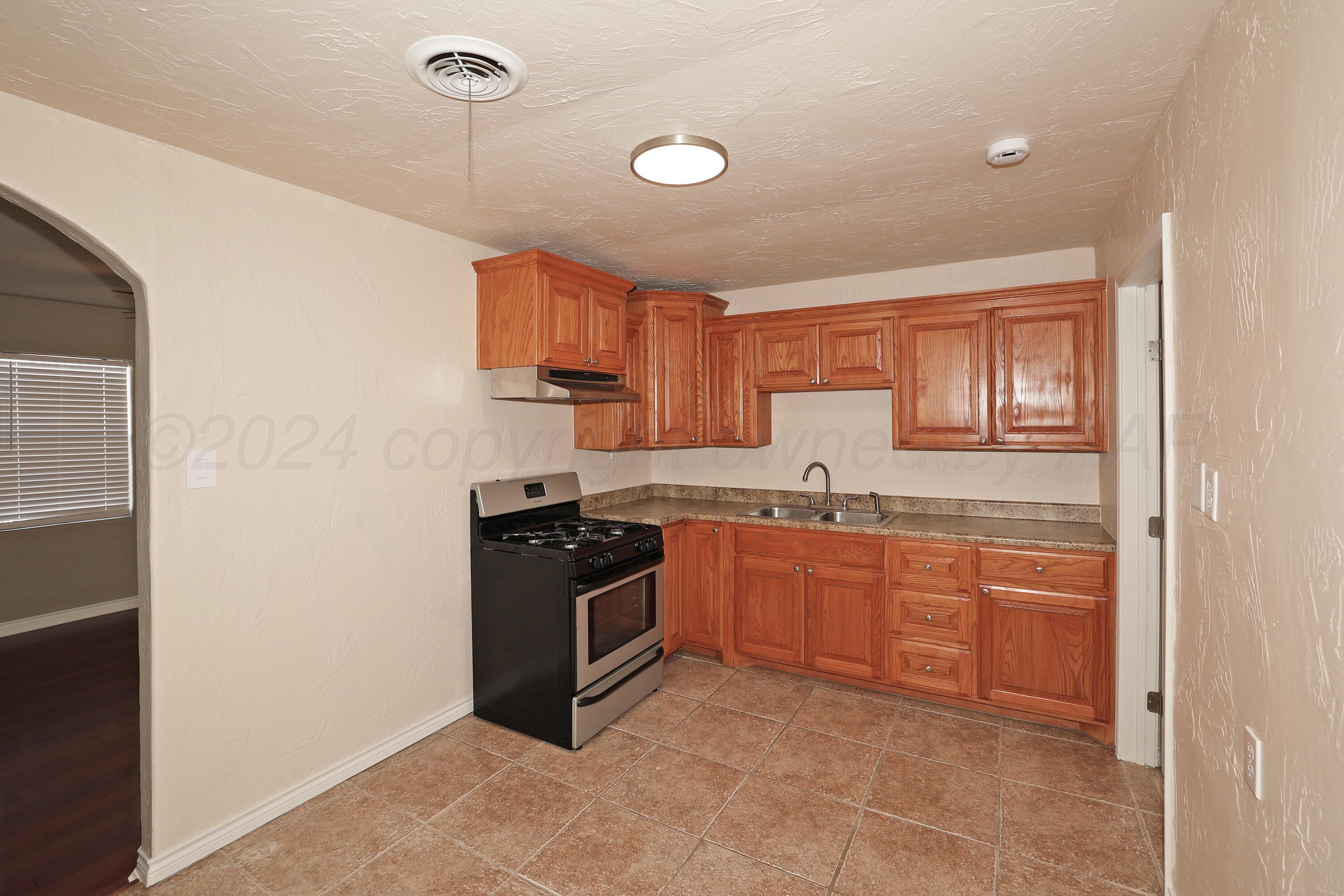 4612 South Parker Street Amarillo, TX 79110 - Photo 7 of 24 a kitchen with stainless steel appliances granite countertop a stove a sink and a refrigerator