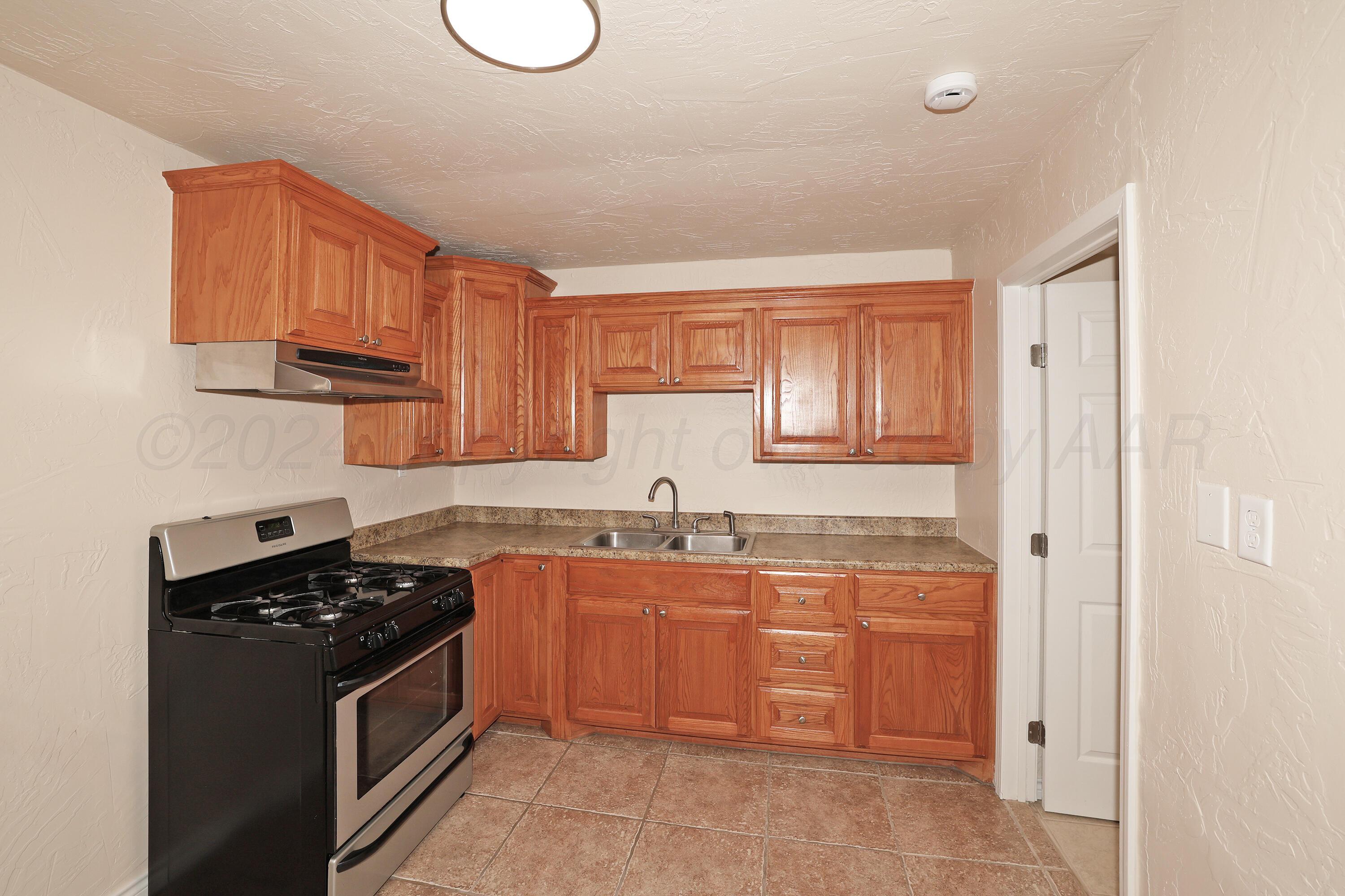 4612 South Parker Street Amarillo, TX 79110 - Photo 8 of 24 a kitchen with stainless steel appliances granite countertop a sink stove refrigerator and cabinets