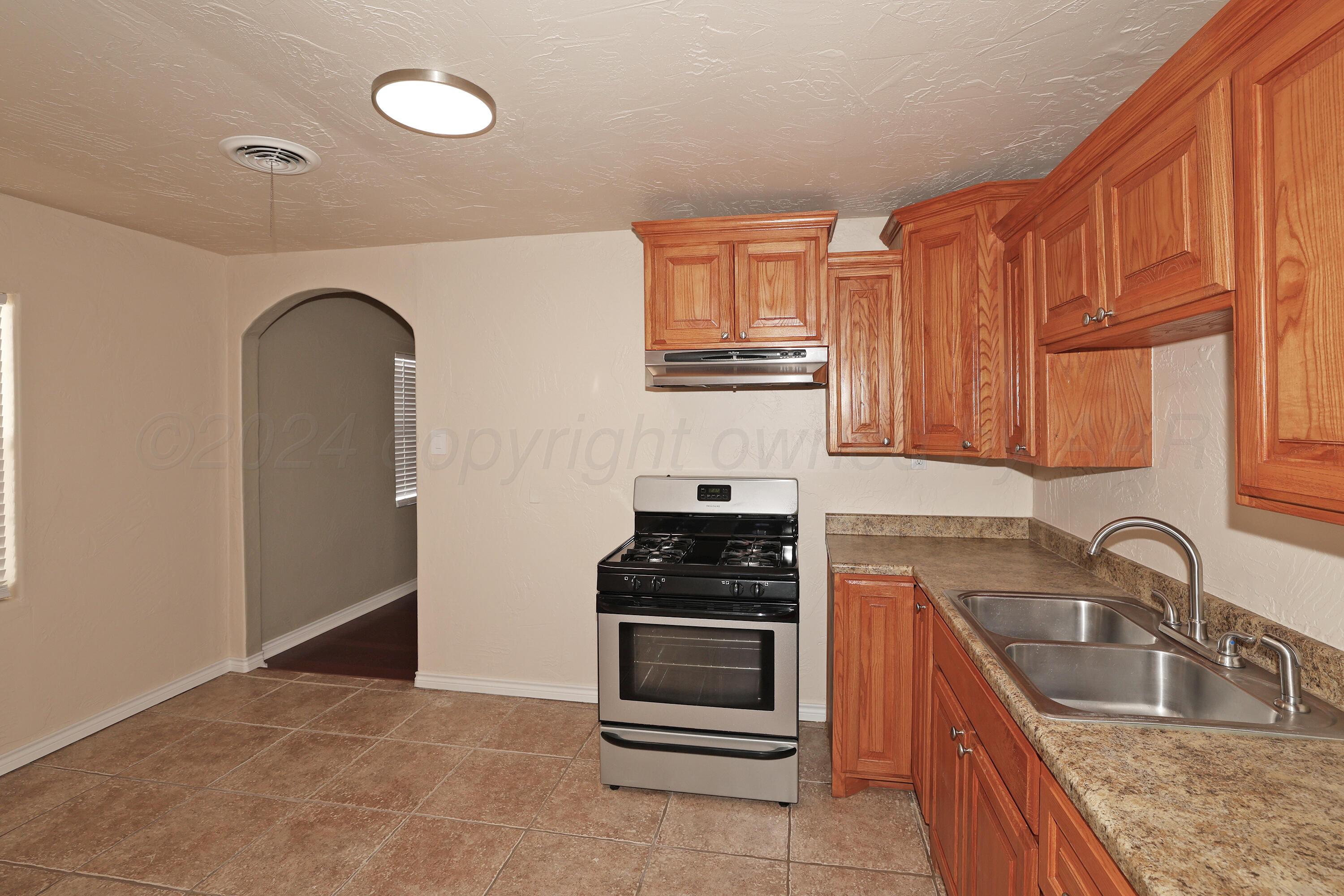 4612 South Parker Street Amarillo, TX 79110 - Photo 9 of 24 a kitchen with granite countertop a sink cabinets and stainless steel appliances