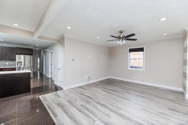 a view of a livingroom with a ceiling fan window a ceiling fan and wooden floor