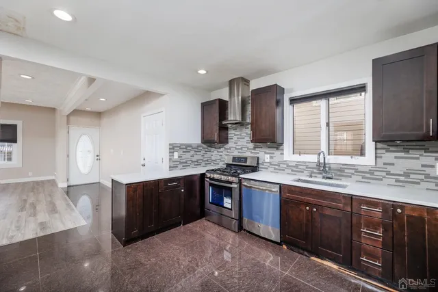 a kitchen with stainless steel appliances granite countertop wooden cabinets and sink