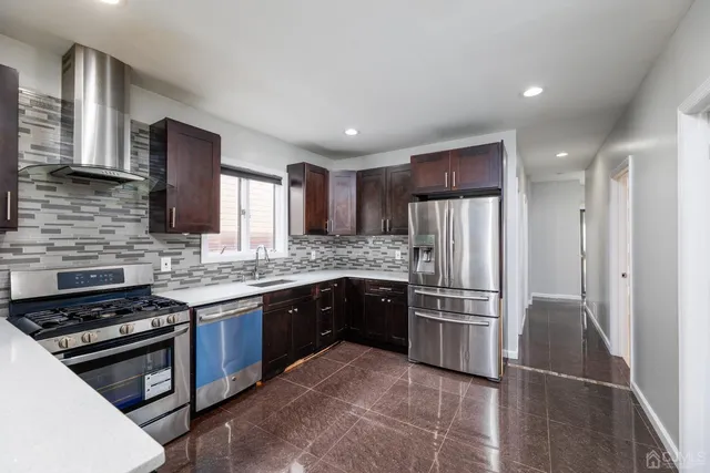 a kitchen with granite countertop stainless steel appliances and wooden cabinets
