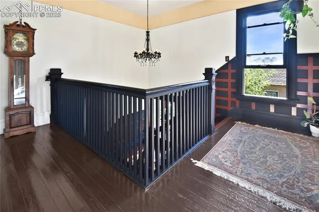 a view of hallway with a window and wooden floor