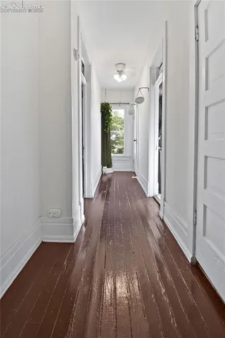 a view of a hallway with wooden floor and closet