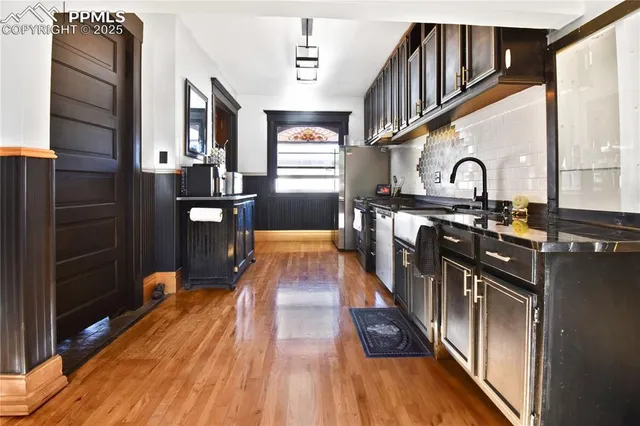 a kitchen with stainless steel appliances granite countertop a stove and a wooden floor